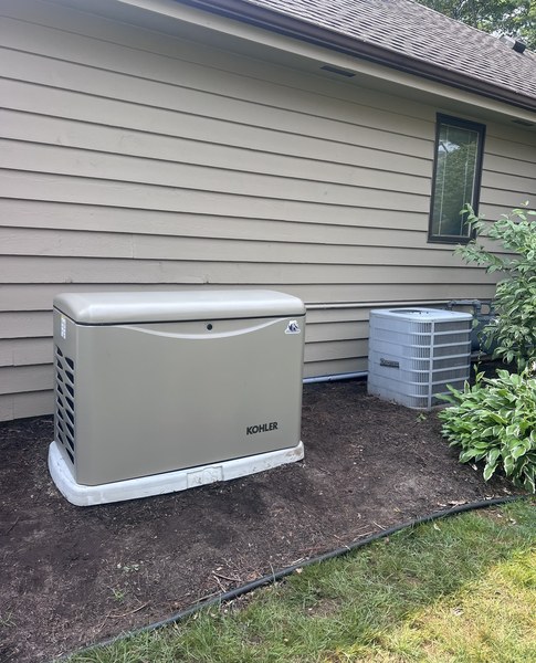 Kohler standby generator installed beside the air conditioning unit at a lap-sided home